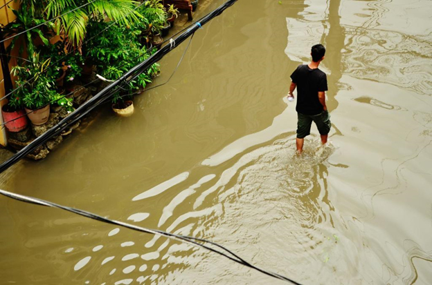 A man wades through shallow flood waters in a street in the Villamor area of Pasay City. Supertyphoon Glenda brought torrential rains and 160 kph winds as it passed over Metro Manila in July. Toby Roca/UP Journalism Club